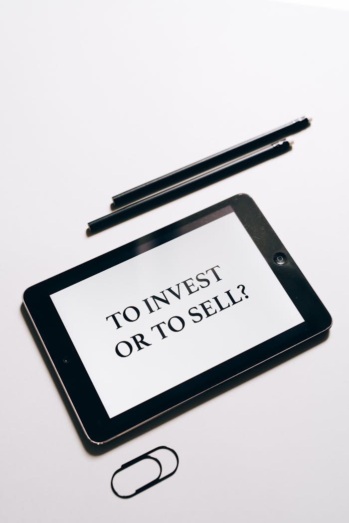 Tablet displaying To Invest or To Sell? question, symbolizing investment decisions.